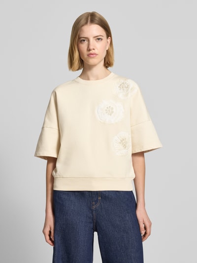 Frauenmodel trägt Sweatshirt mit 1/2-Arm Modell 'MINDULI' von Drykorn, cremefarben, Baumwolle, Loose Fit, Motiv-Stitching, Ganzkörperansicht von vorne.