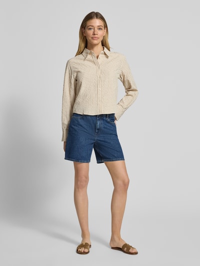 Frauenmodel trägt Straight Leg Bermudas aus reiner Baumwolle Modell 'EMI' von Tommy Hilfiger in Denim-Optik, Regular-Fit, 5-Pocket-Design mit Label-Patch und Logo-Applikation, Knopf und verdecktem Reißverschluss, Ganzkörperansicht von vorne.