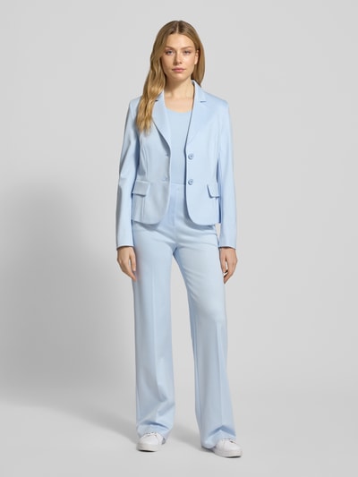 Frauenmodel trägt Stoffhose aus Viskose-Mix mit Bügelfalten von Marc Cain, Regular-Fit, hellblauer Farbton, Ganzkörperansicht von vorne, Damenmode, Stretch-Anteil, Label-Detail, Reißverschlusstaschen, elastischer Bund, Bundweite 37 cm, Innenbeinlänge 80 cm bei Größe 36.
