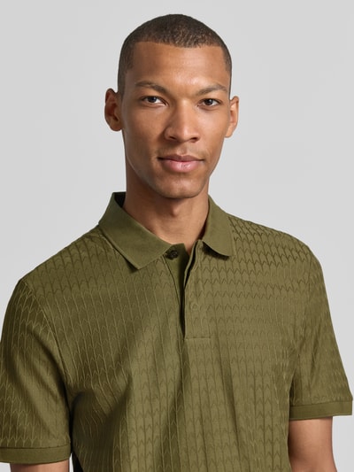 Männermodel trägt olivgrünes Regular Fit Poloshirt aus reiner Baumwolle Modell 'Parley 321' von BOSS, Nahaufnahme Oberkörper, Herren Poloshirt von BOSS.