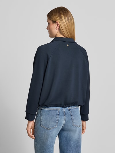 Vrouwenmodel draagt donkerblauwe sweatjack met tweewegritssluiting Model 'Taimi' van JOOP!, Materiaalmix met modaal, relaxed fit, platte kraag, steekzakken, tunnelkoord. Ganzkörperansicht Rückansicht.