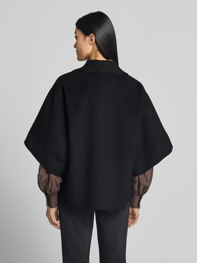 Frauenmodel trägt Regular Fit Kurzmantel aus reiner Schurwolle Modell 'NEO' von Weekend Max Mara in Schwarz mit Kurzarm und Reverskragen, unifarbene Optik, gebürstete Textur, Ganzkörperansicht Rückansicht.