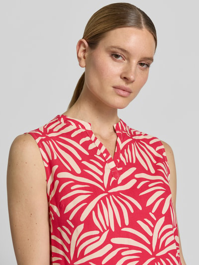 Frauenmodel trägt Regular Fit Blusentop aus Viskose Modell 'Iv44anka' von ZABAIONE mit rot-beigem Allover-Blattmuster, Nahaufnahme Oberkörper.