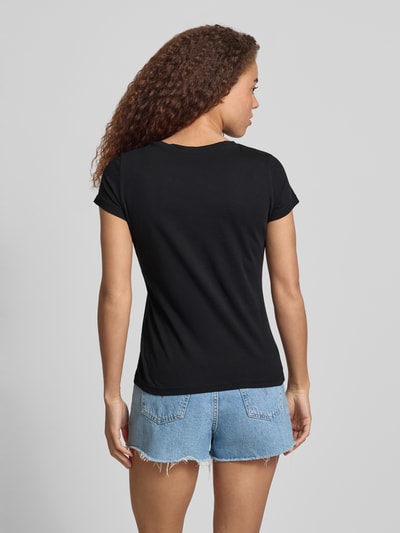 Kobiece modelka nosi Regular Fit T-Shirt mit Logo-Print Modell 'Loa' od Mustang, czarna bawełna, krótkie rękawy, widok tyłem, Ganzkörperansicht Rückansicht.