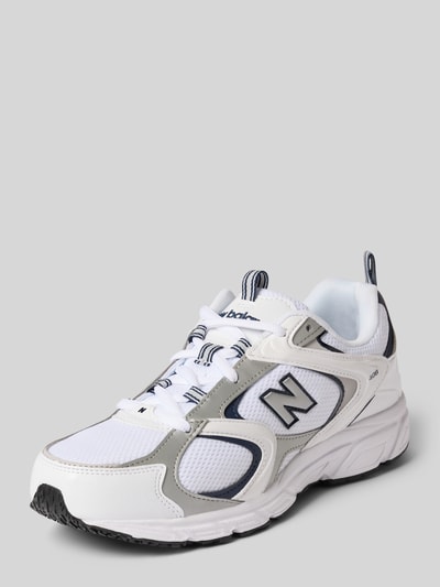Produktfoto, Sneaker mit Logo-Detail Modell '408' von New Balance, weiß mit grauen und schwarzen Akzenten, abgerundete Passform, leicht profilierte Sohle, Absatzhöhe 3 cm, Schafthöhe 8 cm, Schaftweite 9 cm, Produktdetails laut Kontext, neutrale graue Hintergrundfarbe