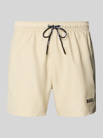 Produktfoto, cremefarbene Badeshorts mit Label-Applikation Modell 'DOGFISH' von BOSS, unifarbene Optik, elastischer Bund, Regular Fit, seitliche Eingrifftaschen und Gesäßtasche, strukturierte Textur.