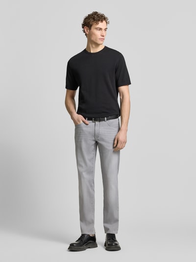 Männermodel trägt graue Sraight Fit Jeans mit Eingrifftaschen Modell 'Cadiz' von Brax, Baumwoll-Elasthan-Mix, Ganzkörperansicht von vorne.