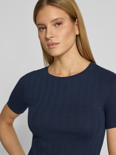 Frauenmodel trägt Slim Fit T-Shirt aus Baumwoll-Mix von Tom Tailor Denim in Dunkelblau mit feinem Strukturmuster, Nahaufnahme Oberkörper.
