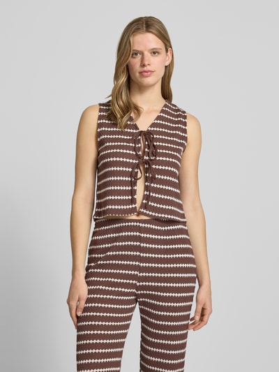 Frauenmodel trägt Regular Fit Weste mit Baumwoll-Anteil Modell 'EVA LIFE' von Only im Allover-Muster, V-Ausschnitt, Strick, Braun-Weiß, Nahaufnahme Oberkörper.
