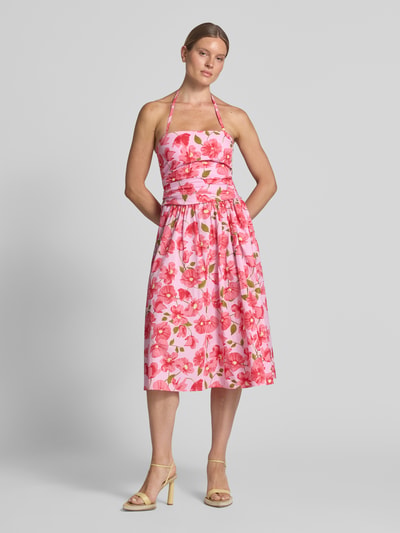 Frauenmodel trägt Midirock im Allover-Look Modell 'CASTLE' von MANGO in Rosa mit Blumenmuster, reine Baumwolle, A-Linie, Ganzkörperansicht von vorne.