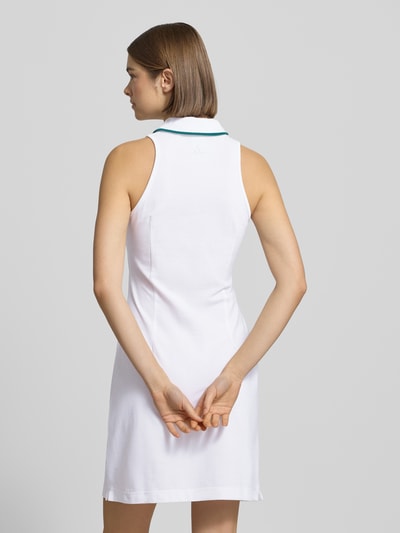 Młodzieżowy model nosi Minikleid mit Hemdblusenkragen od adidas Sportswear, biała bawełna, krótka długość, dopasowany krój, widok całej sylwetki z tyłu.
