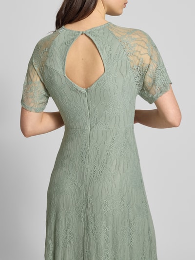 Frauenmodel trägt Maxikleid aus Spitze mit Rundhalsausschnitt Modell 'FEMMA' von Vila, Material-Mix mit Stretch-Anteil, Gerader-Schnitt in Grün, florale Struktur, Rückenlänge 132 cm, Brustweite 46 cm, Ärmellänge 20 cm, Ganzkörperansicht Rückansicht.