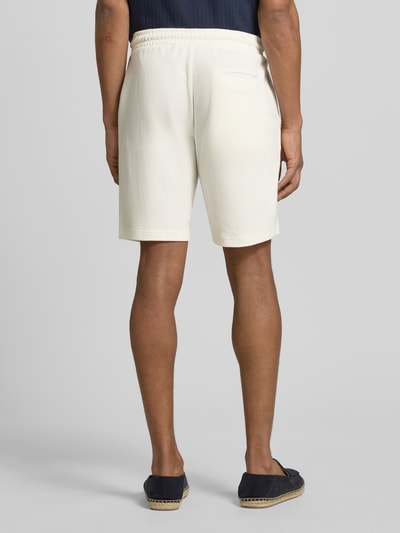 Männermodel trägt Shorts aus Baumwolle mit Strukturmuster von Christian Berg Men in Creme, Regular Fit, elastischer Bund, Ganzkörperansicht Rückansicht.