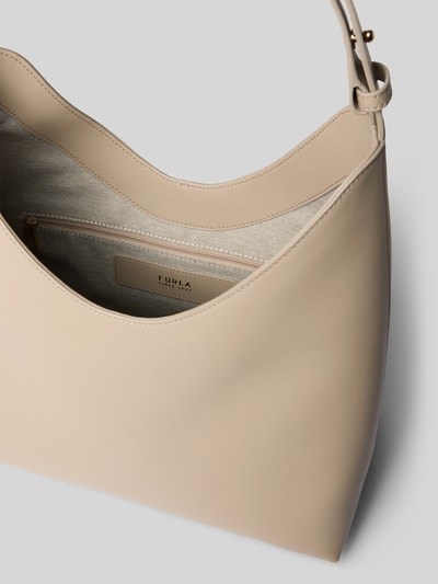 Produktfoto, Handtasche mit Logo-Detail Modell 'Goccia' von FURLA in Beige mit Hauptfach, Riemenverschluss und verstellbarem Trageriemen, Maße 25 cm Breite, 31 cm Länge, 15 cm Tiefe, 42 cm Schulterriemenlänge. Strukturierte, matte Oberfläche mit Innenfach und goldfarbenen Details.