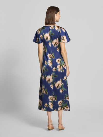 Frauenmodel trägt Cocktailkleid in Midilänge Modell 'Leonie' von GUIDO MARIA KRETSCHMER WOMAN aus Satin, florales Muster, Ganzkörperansicht Rückansicht.