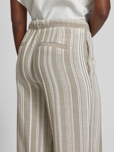 Frauenmodel trägt Culotte mit Kordelzug und Eingrifftaschen von Christian Berg Woman, beige mit weißen Streifen, Detailaufnahme Rückansicht. Elastischer Bund, angedeutete Gesäßleistentaschen und französische Eingrifftaschen, lockerer Schnitt, glatte Textur.