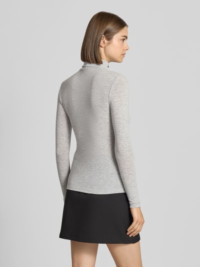 Frauenmodel trägt Regular Fit Langarmshirt mit Viskose-Anteil Modell 'GLAMOUR' von ONLY, hellgrau, glatte Textur, Ganzkörperansicht Rückansicht, Damen Langarmshirt von ONLY.