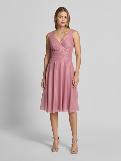 Frauenmodel trägt knielanges Cocktailkleid mit V-Ausschnitt von TROYDEN COLLECTION, Chiffon, Taillierter Schnitt, Breite Träger, Ganzkörperansicht von vorne.