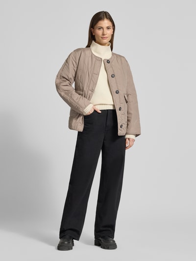 Vrouwenmodel draagt Regular Fit Steppjacke met Pattentaschen Modell 'MILLIE' van Vero Moda, beige, effen, zonder kraag, lange mouwen, knoopsluiting, gestepte structuur, frontaal totaalbeeld.