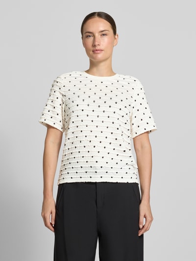 Modelka nosi Boxy Fit T-Shirt mit Allover-Muster von Jake*s Casual, kremowe z czarnym wzorem na całej powierzchni, teksturowany materiał, damski t-shirt, Ganzkörperansicht von vorne.