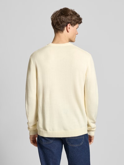 Männermodel trägt Strickpullover mit Logo und Rundhalsausschnitt von Dickies in Creme, Regular Fit, Rippenbündchen, Ganzkörperansicht Rückansicht.
