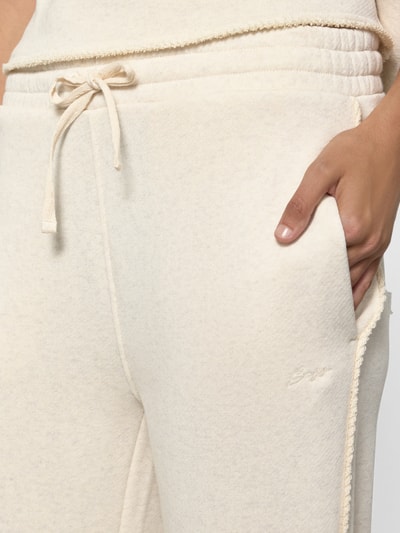 Frauenmodel trägt Regular Fit Sweathose aus Baumwoll-Mix Modell 'C_EVIA' von BOSS Orange in Creme, Damen Sweathose, Nahaufnahme Oberkörper.