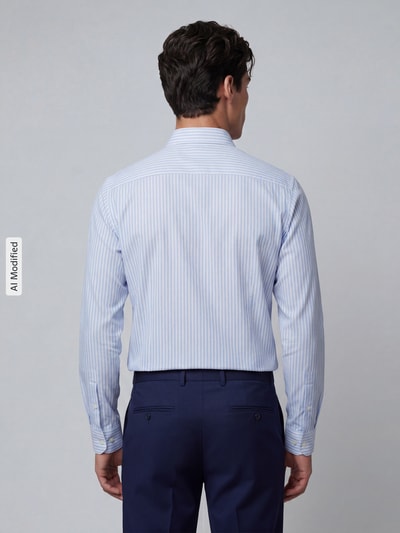 Männermodel trägt Slim Fit Businesshemd mit extra langem Arm von Jake*s mit feinen blauen Streifen, elastischem Material, Rückansicht.