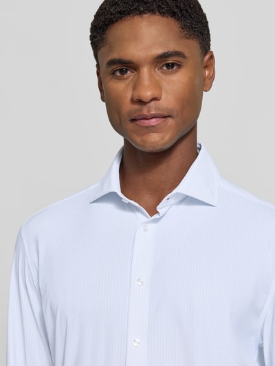 Męski model nosi Slim Fit Businesshemd mit Cutaway-Kragen von Seidensticker, jasnoniebieskie, subtelny pasiasty wzór, zbliżenie na górną część ciała, koszule biznesowe.