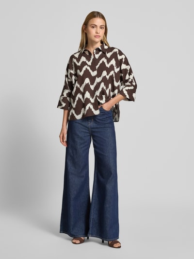 Frauenmodel trägt Bluse aus Viskose-Mix mit 3/4-Arm Modell 'FAWEN' von OPUS PANTS, braun-weiß gemustert, Ganzkörperansicht von vorne, Damen Bluse, Leinen-Viskose-Anteil, Straight Fit, Hemdblusenkragen, verdeckte Knopfleiste, Rückenlänge 60 cm, Ärmellänge 38 cm.
