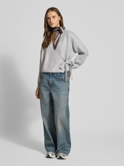 Frauenmodel trägt Regular Fit Cardigan mit Woll-Anteil Modell 'KIRA' von ONLY, Optik: Unifarben, Melange, Strickoptik, Wickeloptik, Taillengürtel, V-Ausschnitt, Langarm, Bündchen gerippt, Material-Mix mit Woll-Anteil, Ganzkörperansicht von vorne.
