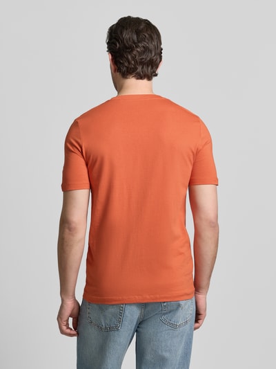 Männermodel trägt Regular Fit T-Shirt aus reiner Baumwolle von s.Oliver RED LABEL in Orange, unifarben, Ganzkörperansicht Rückansicht.