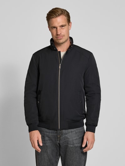 Männermodel trägt Regular Fit Jacke mit Stehkragen von Christian Berg Men in Dunkelblau, Reißverschluss, Eingrifftaschen, Ganzkörperansicht von vorne. Rückenlänge, Schulterbreite, Brustweite und Ärmellänge laut Größe M.