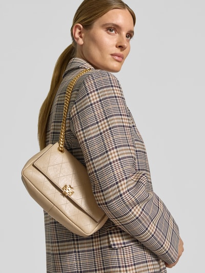 Vrouwenmodel draagt Shoulder Bag met Klickverschluss van Tory Burch in beige met stiksels, goudkleurige schouderketting, labeldetail, product heeft hoofdvak met klep, binnenvak, breedte 25 cm, lengte 12 cm, diepte 8 cm, schuin van voren gefotografeerd, close-up bovenlichaam.