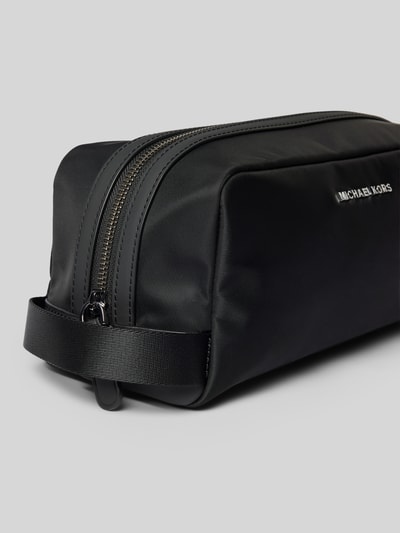 Produktfoto, Travel Kit mit Logo-Applikation Modell 'Brooklyn' von Michael Kors in Schwarz, Reißverschluss, glatte Oberfläche, rechteckige Form, Außenfach und Schulterriemen sind sichtbar