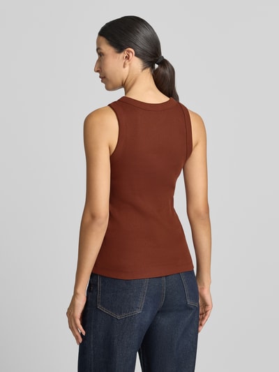 Frauenmodel trägt Skinny Fit Tanktop aus reiner Baumwolle von DRYKORN in Braun, Ripp-Optik, kombiniert zu Jeans, Ganzkörperansicht Rückansicht.