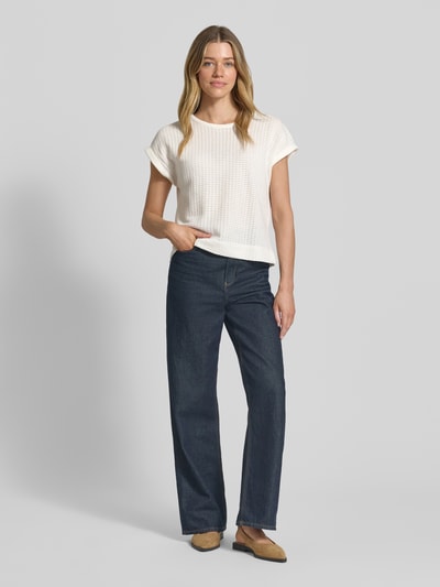 Frauenmodel trägt Strickshirt mit Rundhalsausschnitt Modell 'Sishell' von OPUS in Weiß, kombiniert mit dunkelblauer Jeans, Ganzkörperansicht von vorne.