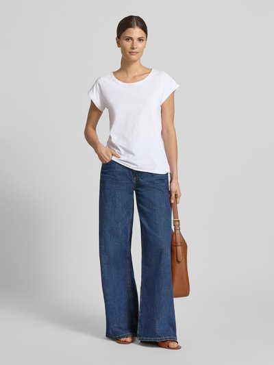 Modelka nosi T-Shirt mit Rundhalsausschnitt von Christian Berg Woman z czystej bawełny, krój regular fit, zrolowany brzeg, długość tyłu w rozmiarze S 61 cm, kolor biały, gładka faktura, widok całej sylwetki z przodu.