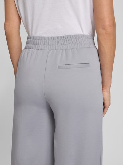 Kobiece modelka nosi spodnie materiałowe Wide Fit z dodatkiem wiskozy model 'Kate' od ICHI, elastyczna mieszanka materiałów, kieszeń z tyłu, zakładki w pasie, elastyczny pas, kolor szary, zbliżenie na tył.