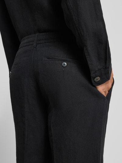 Männermodel trägt schwarze Straight Leg Leinenhose mit Tunnelzug Modell 'LEROY' von SELECTED HOMME, Flammgarn-Struktur, Nahaufnahme Rückansicht