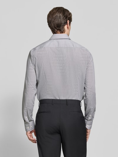 Männermodel trägt Slim Fit Businesshemd aus reiner Baumwolle Modell 'HANK' von BOSS, hellgrau, klare Linien, Ganzkörperansicht Rückansicht.