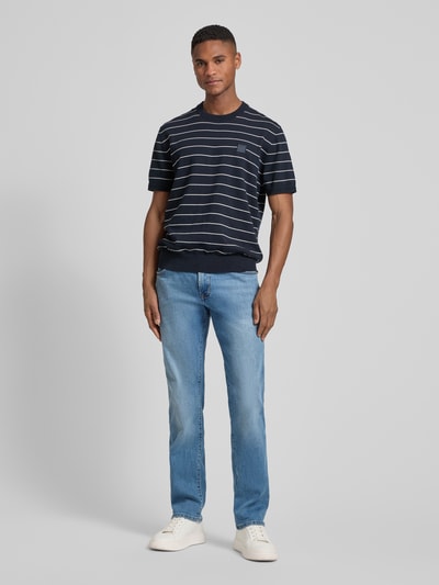 Männermodel trägt Regular Fit Jeans mit Eingrifftaschen Modell 'Dijon' von Pierre Cardin in hellblau, Baumwoll-Mix mit Stretch-Anteil, Ganzkörperansicht von vorne.