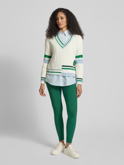Kobiece model nosi Slim Fit Leggins mit elastischem Bund od Marc Cain, elastyczna mieszanka materiałów, krój slim fit, ozdobne obszycie; szerokość w rozmiarze 36: 34 cm, długość wewnętrzna nogawki w rozmiarze 36: 76 cm, zielony kolor, gładka tekstura; widok całej sylwetki z przodu.