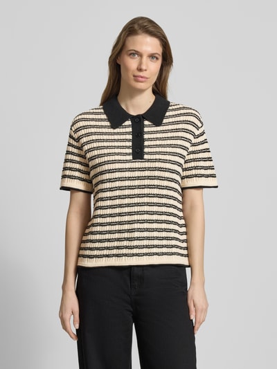 Frauenmodel trägt Strickshirt mit Polokragen Modell 'CHANY' von ICHI aus Baumwoll-Mix, Regular-Fit, gestreift in Beige und Schwarz, Nahaufnahme Oberkörper.