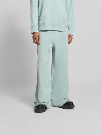 Männermodel trägt Wide Fit Sweatpants mit elastischem Bund von MM6 Maison Margiela, Reine Baumwolle, Logo-Stitching, Gesäßtasche, Ganzkörperansicht von vorne.