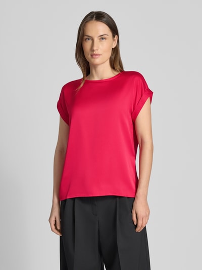 Kobiece modelka nosi damski t-shirt z mieszanki wiskozy i elastanu, luźny krój, okrągły dekolt, Model 'ELLETTE' od Vila, długość tyłu 57 cm w rozmiarze 36, kolor różowy, gładka tekstura, widok na cały korpus od przodu.