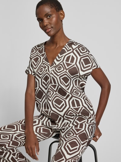 Frauenmodel trägt Regular Fit Bluse aus Viskose Modell 'Amber' von TONI im Allover-Look mit V-Ausschnitt, braun-weiße Muster, Nahaufnahme Oberkörper.
