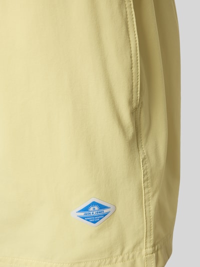 Produktfoto, żółte spodenki kąpielowe Straight Fit Badeshorts mit Logo-Detail Modell 'Maui' von Jack & Jones, detal z logo, elastyczny pas z tunelem