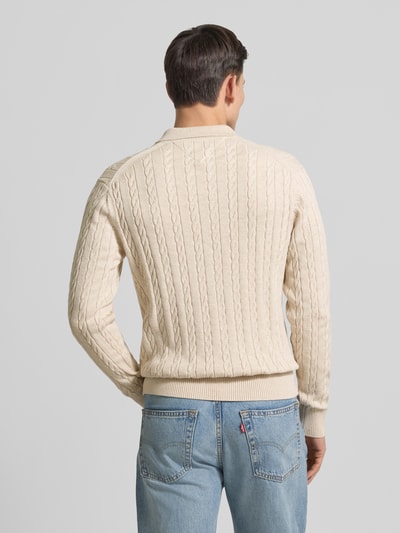 Männermodel trägt Regular Fit Strickpullover aus reiner Baumwolle von Tommy Hilfiger, Optik: Unifarben, Zopfmuster, Ganzkörperansicht Rückansicht.
