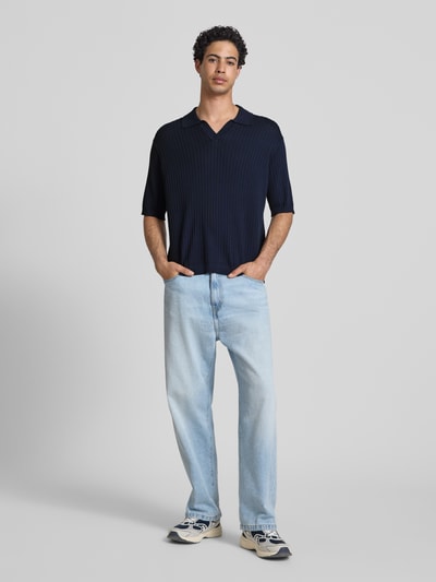 Männermodel trägt Relaxed Fit Poloshirt aus Viskose-Mix Modell 'FLINT' von Only & Sons, Optik: Unifarben, Struktur, Ganzkörperansicht von vorne.