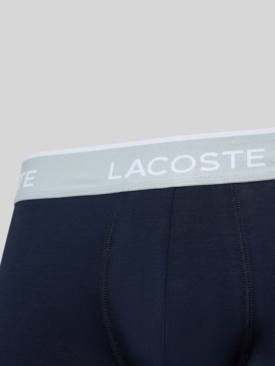 Produktfoto, dunkelblaue Trunk aus Baumwoll-Mix im 3er-Pack von Lacoste, elastischer Bund mit weißem Lacoste-Schriftzug, glatte Oberfläche. Herren Pant & Trunk von Lacoste